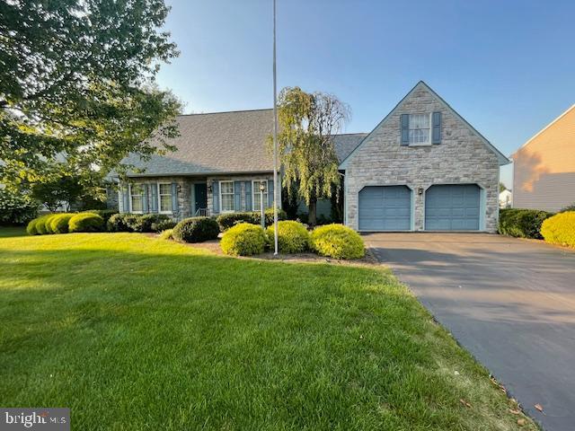 409 Rhoda Dr, Lancaster, PA 17601 - view of front facade featuring stone siding, asphalt driveway, a front yard, and a garage