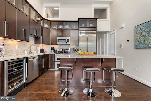 1904 Vermont Ave NW Unit A, Washington, DC 20001 - kitchen featuring beverage cooler, appliances with stainless steel finishes, a kitchen bar, and dark brown cabinetry