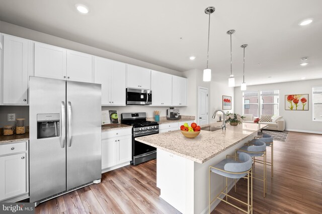 620 Mozart Way, Baltimore, MD 21224 - kitchen featuring stainless steel appliances, wood finished floors, white cabinets, open floor plan, and recessed lighting
