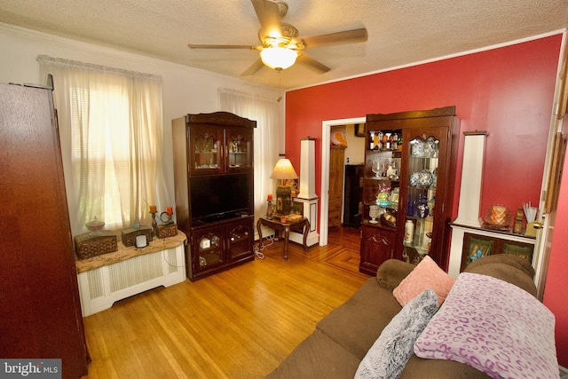 4425 E Howell St, Philadelphia, PA 19135 - living area featuring radiator, ceiling fan, a textured ceiling, wood finished floors, and ornamental molding