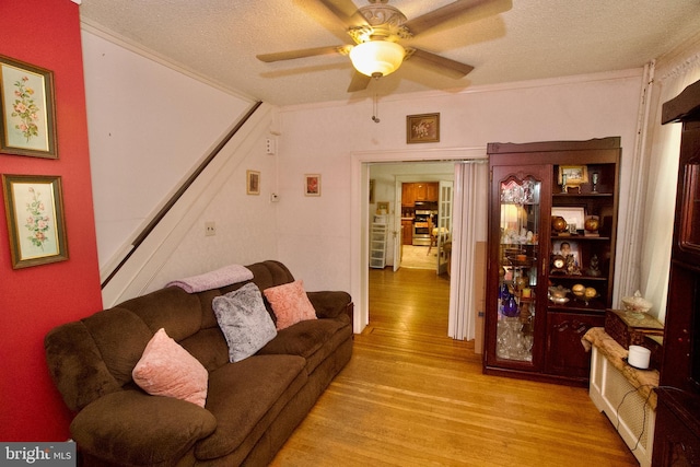 4425 E Howell St, Philadelphia, PA 19135 - living room with wood finished floors, a textured ceiling, stairs, and ceiling fan