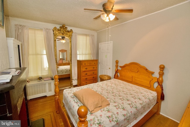 4425 E Howell St, Philadelphia, PA 19135 - bedroom featuring radiator, a textured ceiling, wood finished floors, and ceiling fan