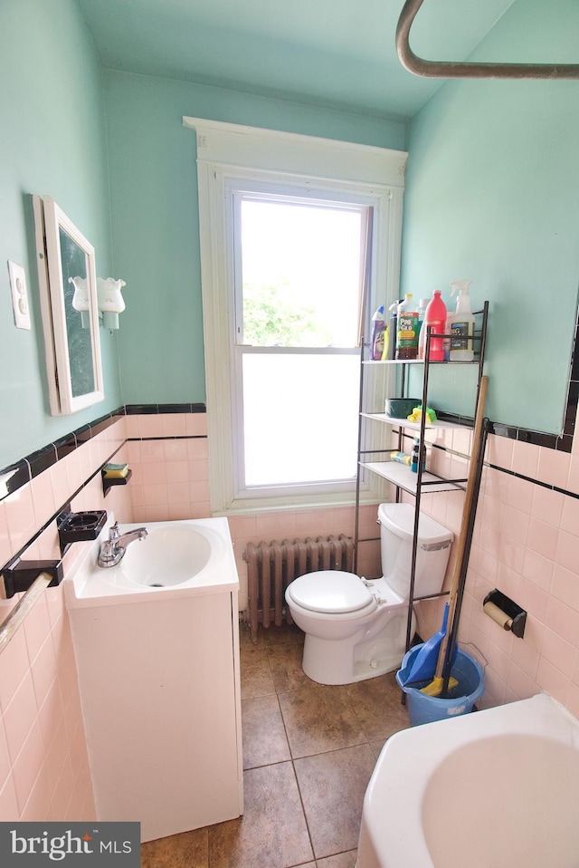 4425 E Howell St, Philadelphia, PA 19135 - bathroom with radiator heating unit, tile walls, tile patterned flooring, vanity, and wainscoting