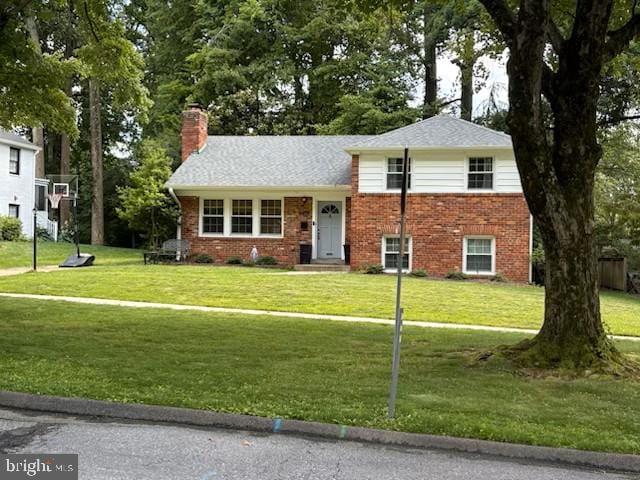 4408 Saul Rd, Kensington, MD 20895 - split level home featuring a chimney, brick siding, a front lawn, and a shingled roof