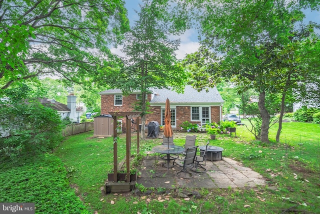 4408 Saul Rd, Kensington, MD 20895 - rear view of property featuring an outdoor fire pit, a patio area, a storage shed, and brick siding