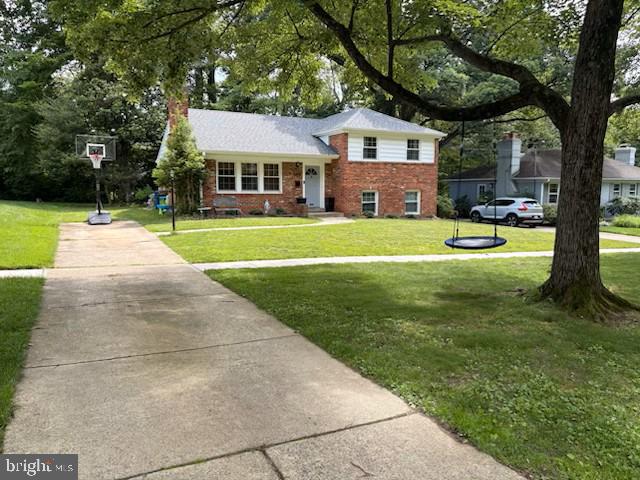 4408 Saul Rd, Kensington, MD 20895 - tri-level home featuring brick siding, a front lawn, and a chimney