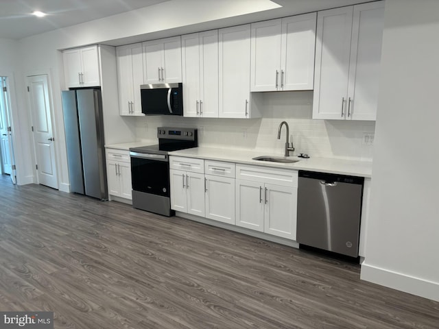 2209 N 7th St, Philadelphia, PA 19133 - kitchen featuring appliances with stainless steel finishes, dark wood-type flooring, light countertops, backsplash, and white cabinetry