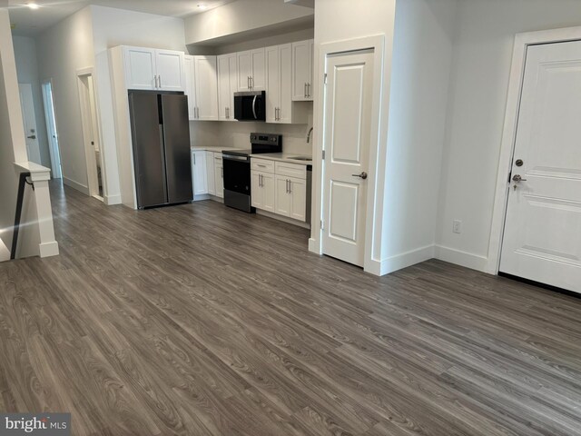 2209 N 7th St, Philadelphia, PA 19133 - kitchen featuring appliances with stainless steel finishes, dark wood-type flooring, and white cabinets