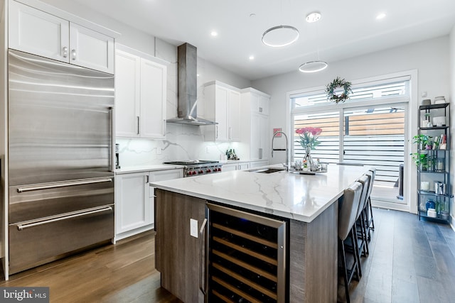 1217 Bainbridge St, Philadelphia, PA 19147 - kitchen with stainless steel appliances, wine cooler, wall chimney range hood, dark wood finished floors, and white cabinets