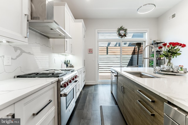 1217 Bainbridge St, Philadelphia, PA 19147 - kitchen featuring appliances with stainless steel finishes, wall chimney range hood, white cabinets, dark wood-type flooring, and decorative backsplash