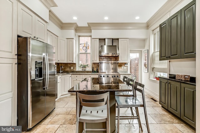 2101 Wallace St, Philadelphia, PA 19130 - kitchen featuring stainless steel refrigerator with ice dispenser, wall chimney range hood, stone tile flooring, ornamental molding, and backsplash