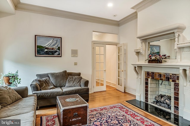 2101 Wallace St, Philadelphia, PA 19130 - living area with crown molding, light wood finished floors, a tiled fireplace, and french doors