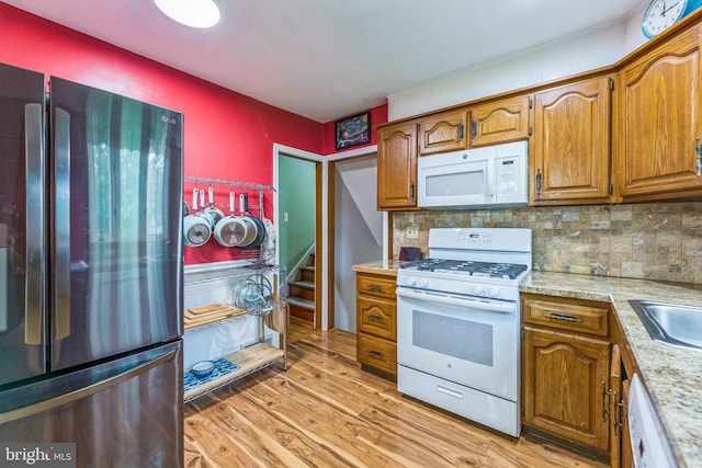 680 Davisville Rd, Warminster, PA 18974 - kitchen featuring white appliances, light countertops, light wood-style floors, and brown cabinets