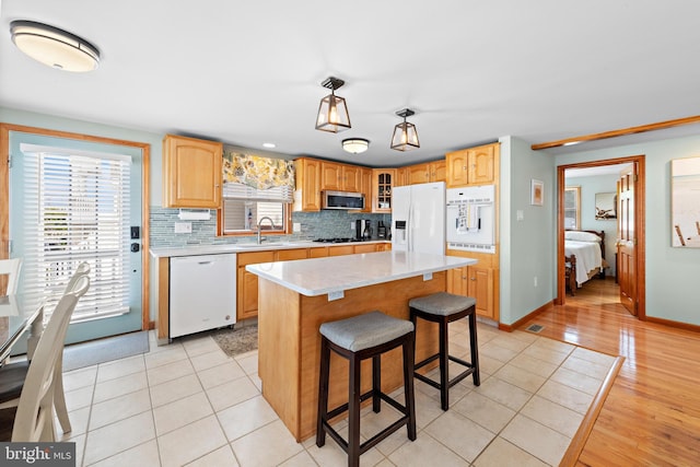 6203 Long Beach Blvd, Long Beach Township, NJ 08008 - kitchen with white appliances, light countertops, a kitchen breakfast bar, decorative backsplash, and glass insert cabinets