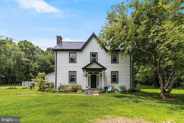 15065 Rock Point Rd, Newburg, MD 20664 - view of front of property featuring a chimney, a front lawn, a storage unit, and a metal roof