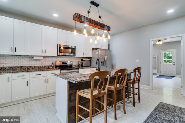 15065 Rock Point Rd, Newburg, MD 20664 - kitchen featuring stainless steel appliances, decorative backsplash, a kitchen breakfast bar, a kitchen island with sink, and recessed lighting