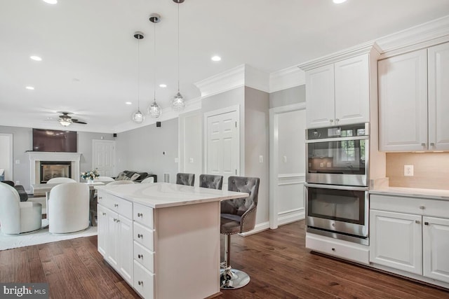1506 White Tail Deer Ct, Annapolis, MD 21409 - kitchen with double oven, a kitchen breakfast bar, white cabinetry, ceiling fan, and decorative light fixtures