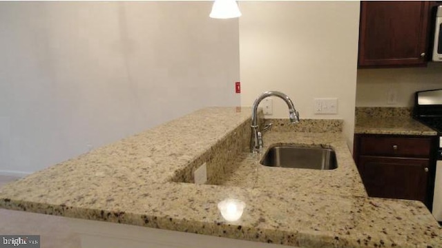 350 W Elm St Unit 3010, Conshohocken, PA 19428 - kitchen with light stone countertops, stainless steel microwave, dark brown cabinets, and a peninsula