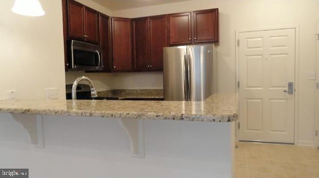 350 W Elm St Unit 3010, Conshohocken, PA 19428 - kitchen featuring stainless steel appliances, a peninsula, dark brown cabinets, light stone counters, and light tile patterned floors