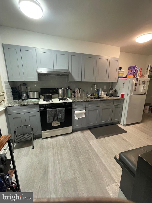 6207 Cardiff St, Philadelphia, PA 19149 - kitchen featuring gas range, under cabinet range hood, freestanding refrigerator, gray cabinetry, and light wood-style flooring