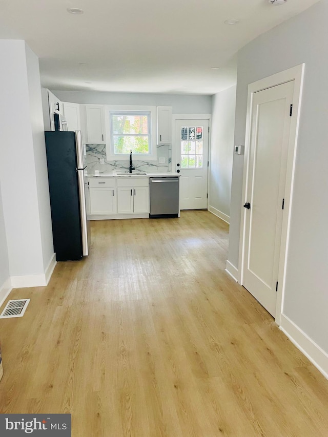 213 N Willow St, Gloucester City, NJ 08030 - kitchen featuring appliances with stainless steel finishes, light countertops, white cabinets, and light wood-type flooring