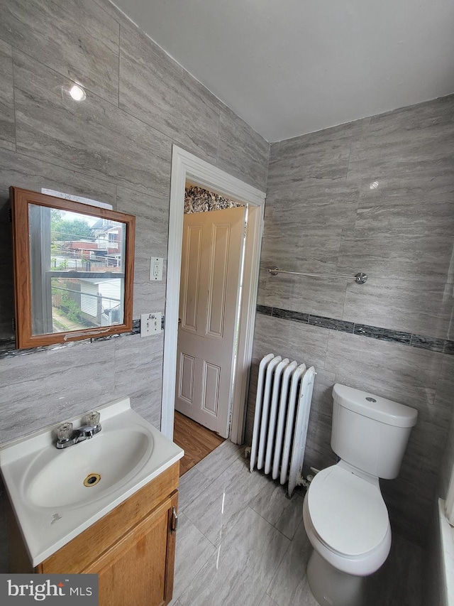 1116 Church St, Reading, PA 19601 - bathroom featuring radiator heating unit, tile walls, and vanity