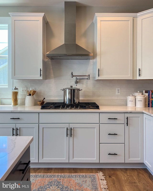23 Old, Banks, Fredericksburg, VA 22406 - kitchen with wall chimney exhaust hood, stainless steel gas stovetop, decorative backsplash, white cabinets, and wood finished floors
