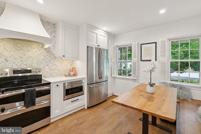 10905 Wickshire Way Unit G-2, North Bethesda, MD 20852 - kitchen with appliances with stainless steel finishes, premium range hood, white cabinetry, decorative backsplash, and plenty of natural light