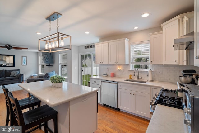 136 Tiller Ave, Manahawkin, NJ 08050 - kitchen with stainless steel dishwasher, ventilation hood, open floor plan, tasteful backsplash, and white cabinetry
