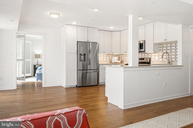 770 Fairview Ave Unit 770D, Annapolis, MD 21403 - kitchen with stainless steel appliances, wood finished floors, backsplash, white cabinetry, and recessed lighting