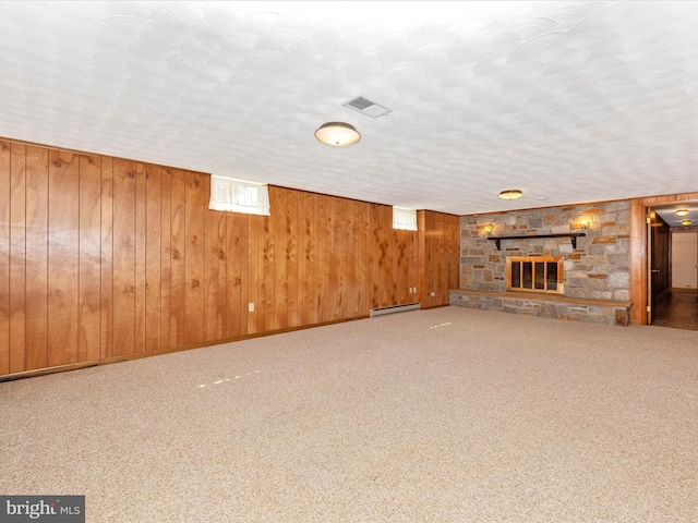 6505 Morningside Ct, Middletown, MD 21769 - basement featuring a baseboard heating unit, a fireplace, wooden walls, carpet, and a textured ceiling