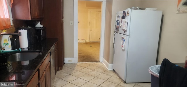 2308 W Mosher St, Baltimore, MD 21216 - kitchen with freestanding refrigerator, light tile patterned floors, light colored carpet, and dark stone countertops