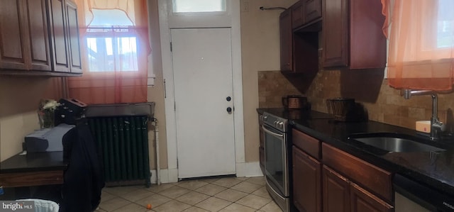 2308 W Mosher St, Baltimore, MD 21216 - kitchen featuring stainless steel appliances, backsplash, radiator, light tile patterned floors, and dark countertops