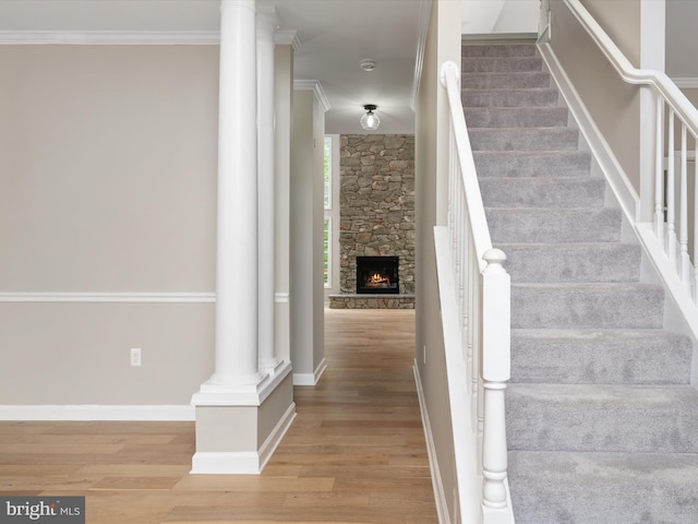 1015 S Creek View Ct, Churchton, MD 20733 - stairway with ornate columns, wood finished floors, a stone fireplace, and ornamental molding