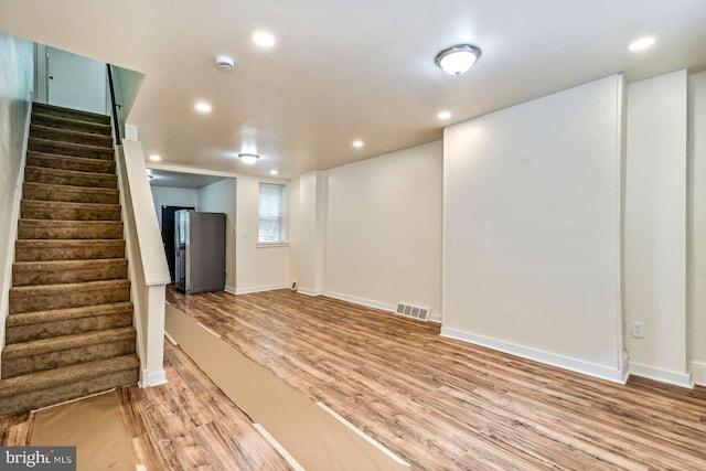 2750 N 28th St, Philadelphia, PA 19132 - below grade area with stainless steel fridge with ice dispenser, wood finished floors, stairway, and recessed lighting