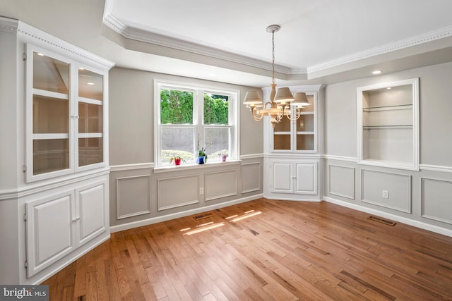 51 E Ann Rd, Broomall, PA 19008 - unfurnished dining area with a chandelier, crown molding, a decorative wall, light wood finished floors, and a tray ceiling
