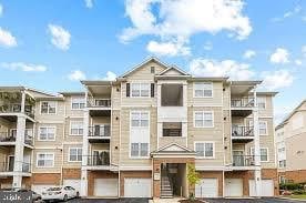 19609 Galway Bay Cir Unit 303, Germantown, MD 20874 - view of apartment building / complex with a garage and driveway