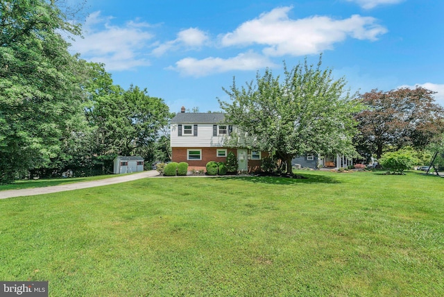 2303 Mulberry Ln, Lafayette Hill, PA 19444 - view of front of home with a storage shed, brick siding, driveway, a front lawn, and a chimney