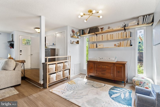 3086 Bridgeton Ct, Woodbridge, VA 22192 - kitchen featuring wood finished floors, a textured ceiling, a chandelier, and open floor plan
