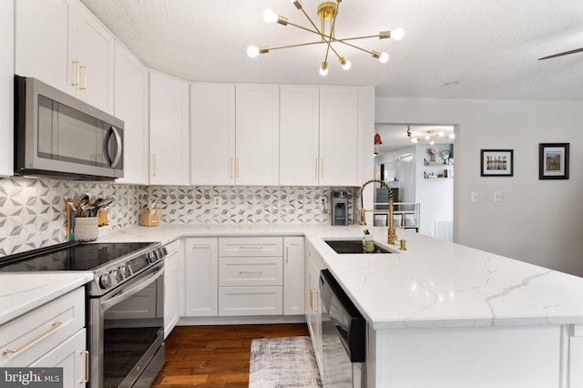 3086 Bridgeton Ct, Woodbridge, VA 22192 - kitchen with appliances with stainless steel finishes, a peninsula, dark wood-style floors, tasteful backsplash, and white cabinetry