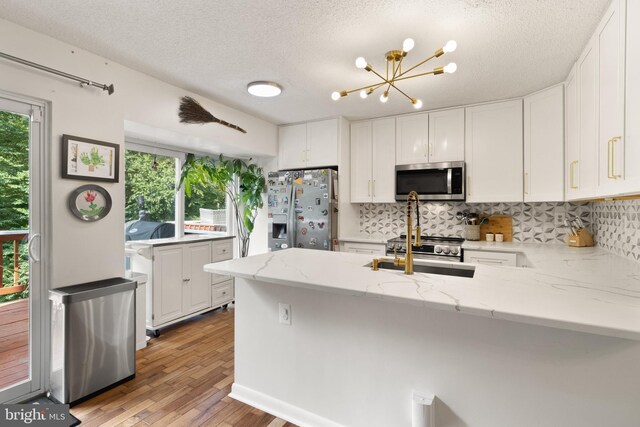 3086 Bridgeton Ct, Woodbridge, VA 22192 - kitchen featuring appliances with stainless steel finishes, backsplash, white cabinetry, and a textured ceiling