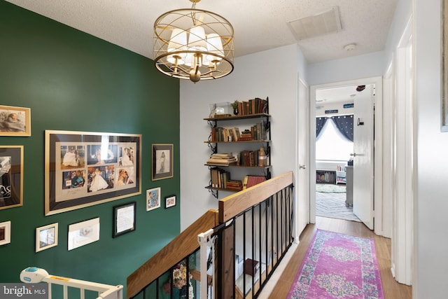 3086 Bridgeton Ct, Woodbridge, VA 22192 - hallway with wood finished floors, a chandelier, and a textured ceiling