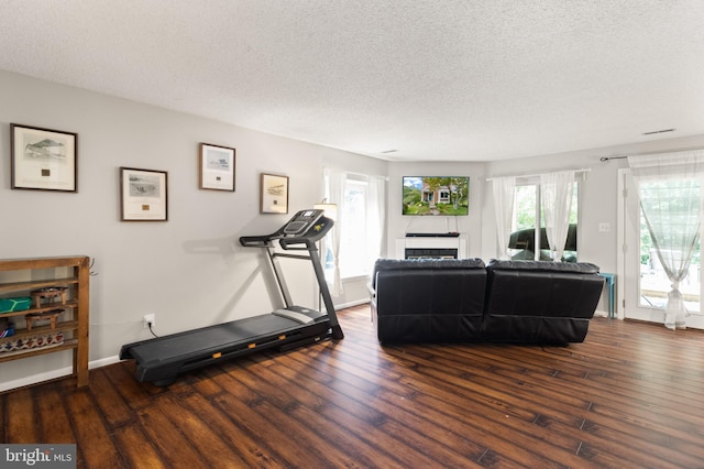 3086 Bridgeton Ct, Woodbridge, VA 22192 - workout room with wood finished floors, a textured ceiling, and a glass covered fireplace