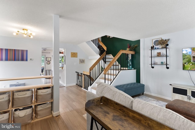3086 Bridgeton Ct, Woodbridge, VA 22192 - living area with wood finished floors, healthy amount of natural light, stairs, a textured ceiling, and a chandelier