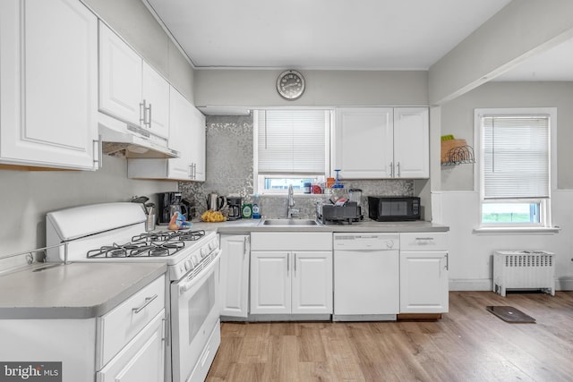 438 Holly Rd, Lansdowne, PA 19050 - kitchen featuring white appliances, radiator heating unit, under cabinet range hood, and plenty of natural light