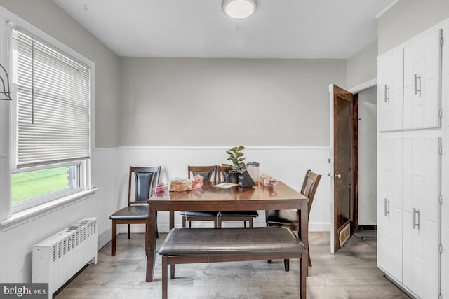 438 Holly Rd, Lansdowne, PA 19050 - dining space with radiator heating unit, a wainscoted wall, and wood finished floors