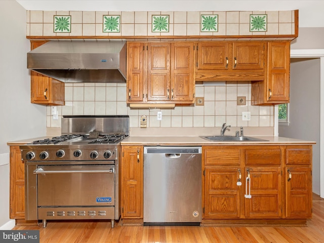 4431 Cherry Tree Ln, Sykesville, MD 21784 - kitchen featuring appliances with stainless steel finishes, exhaust hood, light wood-style floors, and backsplash
