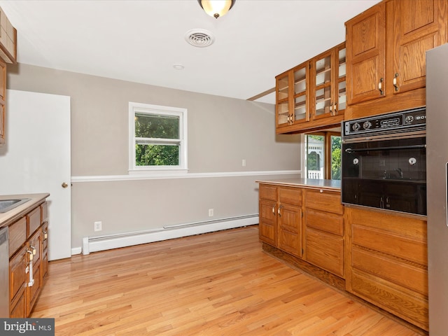 4431 Cherry Tree Ln, Sykesville, MD 21784 - kitchen featuring oven, a baseboard radiator, light wood-type flooring, and brown cabinets
