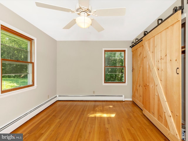 4431 Cherry Tree Ln, Sykesville, MD 21784 - spare room featuring a barn door, baseboard heating, and plenty of natural light