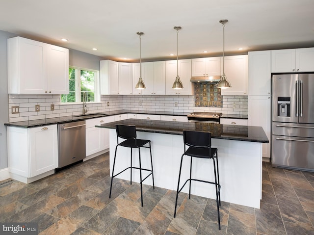 319 W Conestoga Rd, Devon, PA 19333 - kitchen featuring stainless steel appliances, stone tile flooring, a kitchen breakfast bar, white cabinets, and under cabinet range hood